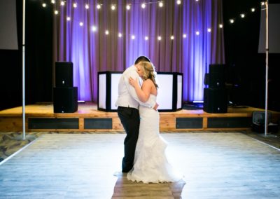 A young couple dancing their first dance with uplighting.