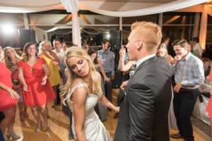A young couple dance with other people on the dance floor.