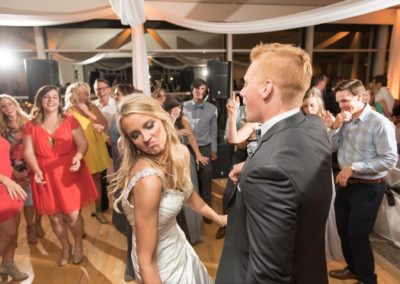 A young couple dance with other people on the dance floor.