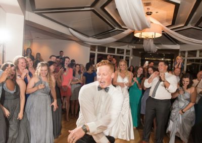 The Groom dances wildly with his friends cheering him on